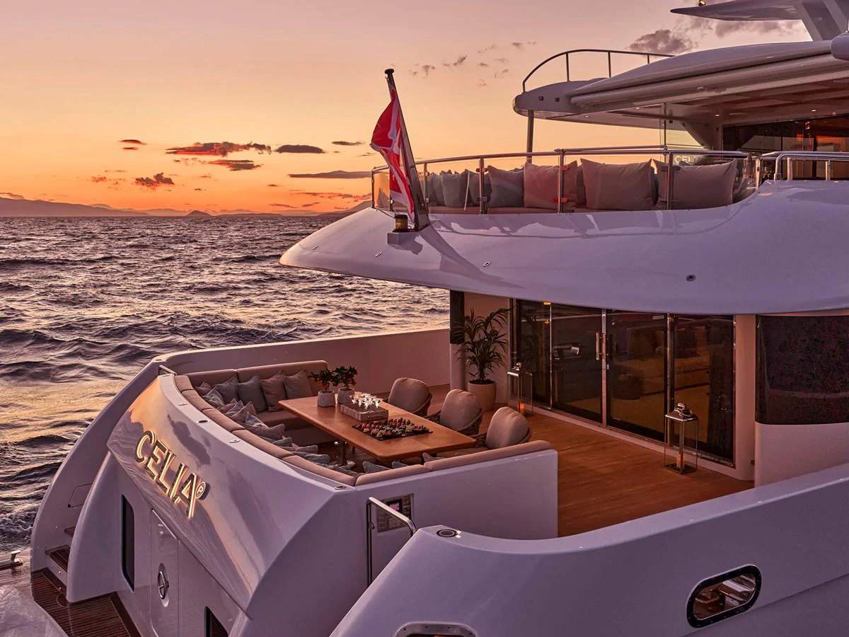 The yacht's aft deck offers a luxurious outdoor dining area with a stunning sunset view. aboard ULYSSES Yacht for Sale