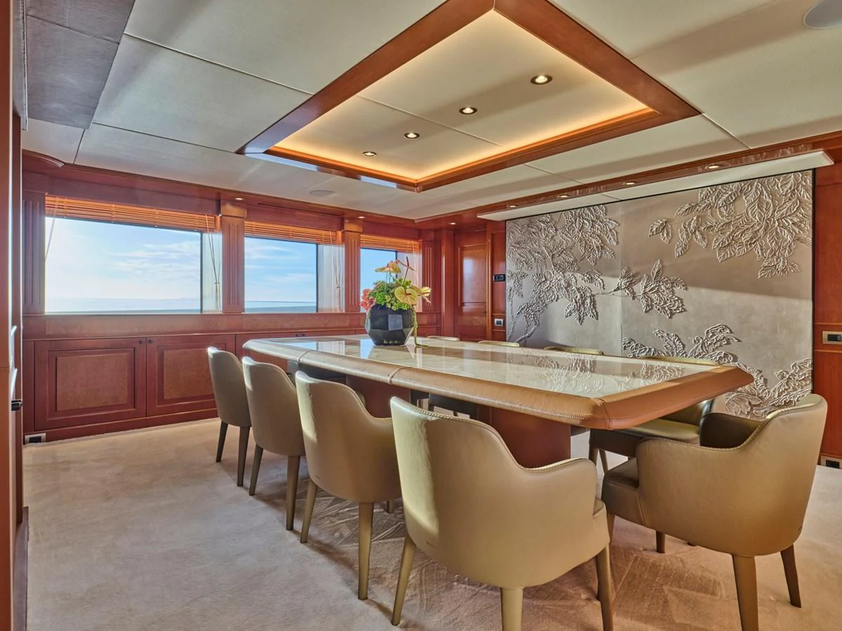 The yacht's dining area features a large table with comfortable seating and elegant decor. aboard ULYSSES Yacht for Sale