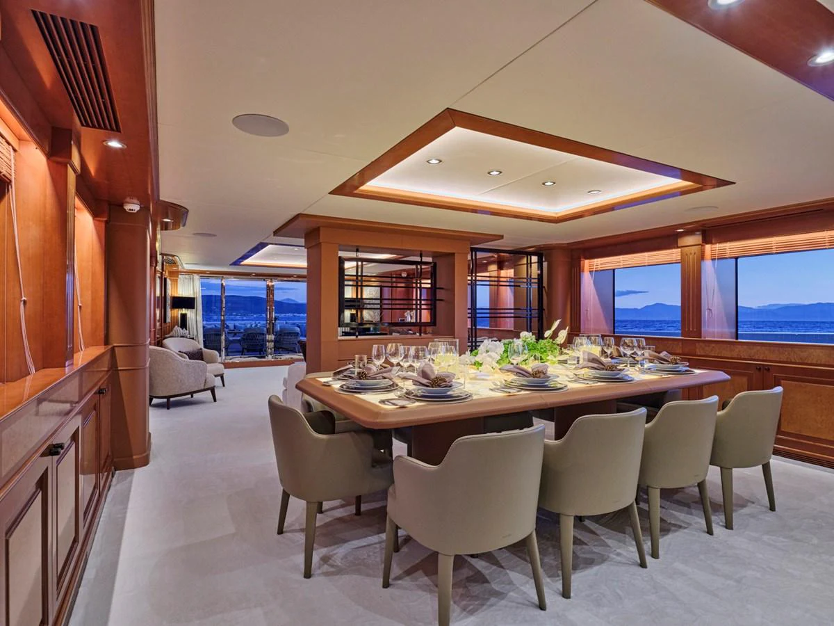 The yacht's dining area features a beautifully set table with elegant seating and ambient lighting. aboard ULYSSES Yacht for Sale