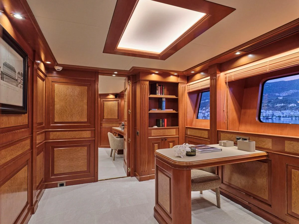 The yacht's office features elegant wood paneling and large windows with scenic views. aboard ULYSSES Yacht for Sale