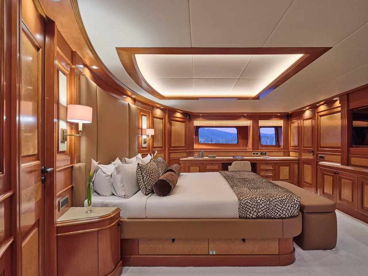 The master stateroom features elegant wood paneling and luxurious bedding. aboard ULYSSES Yacht for Sale
