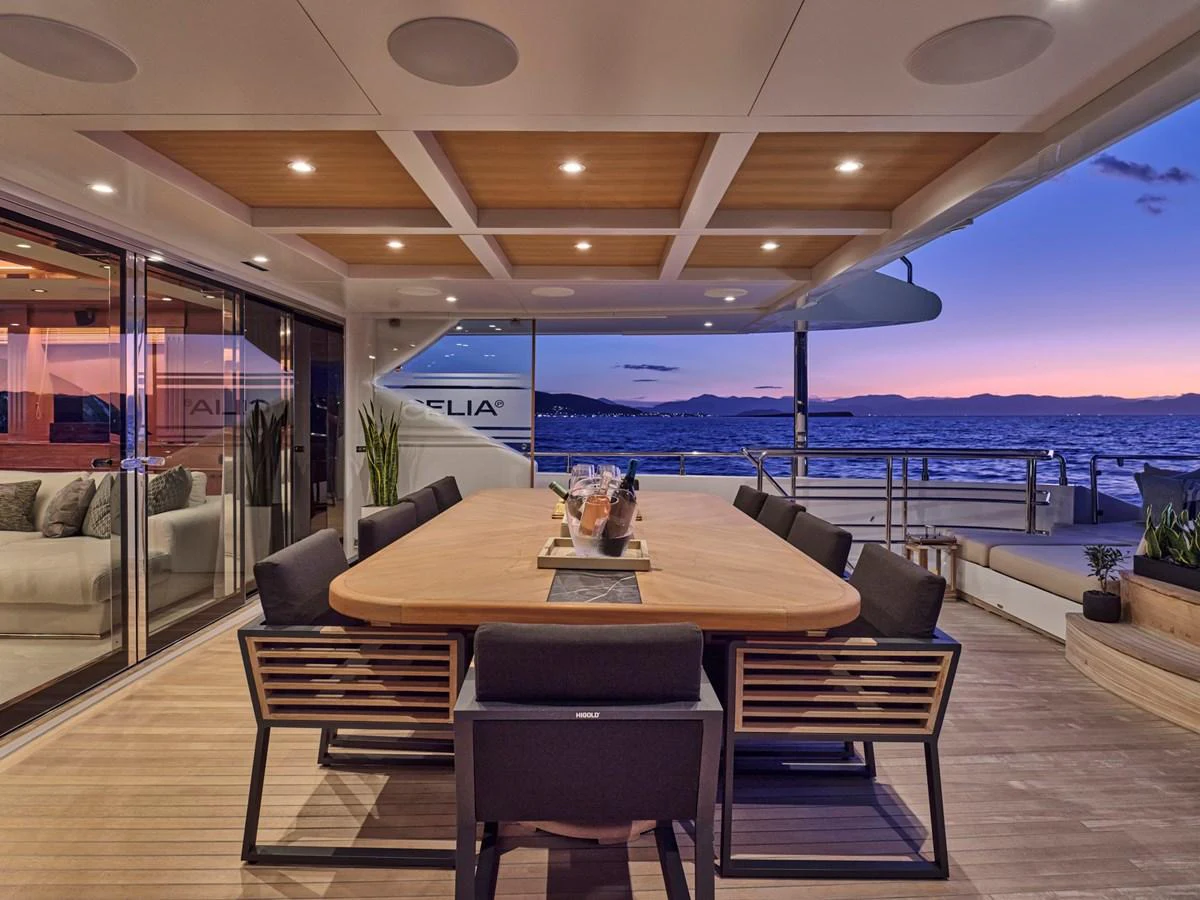 The aft deck features a stylish dining area with a stunning sunset view. aboard ULYSSES Yacht for Sale