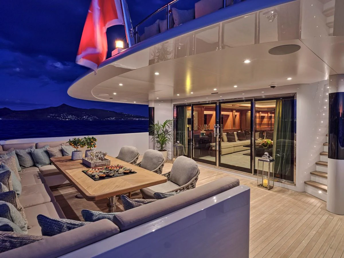 The aft deck offers a luxurious outdoor seating area with a dining table, perfect for evening relaxation. aboard ULYSSES Yacht for Sale