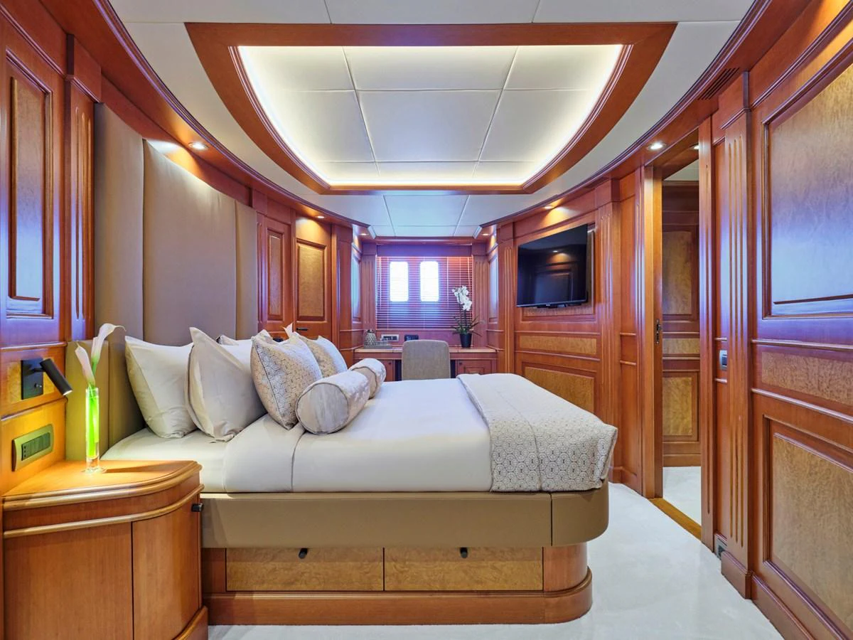 The master stateroom features elegant wood paneling and luxurious bedding. aboard ULYSSES Yacht for Sale