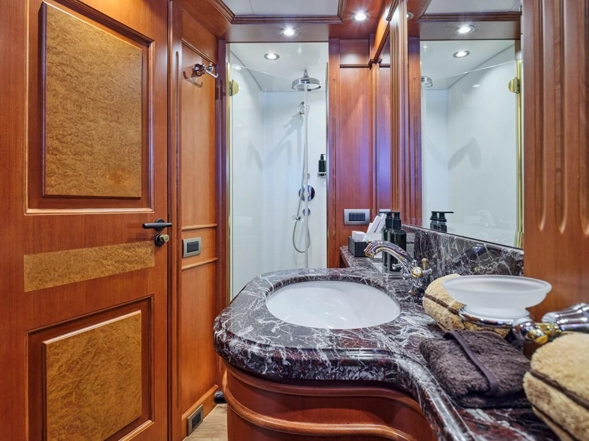 The yacht's bathroom features elegant wood paneling and a marble countertop. aboard ULYSSES Yacht for Sale