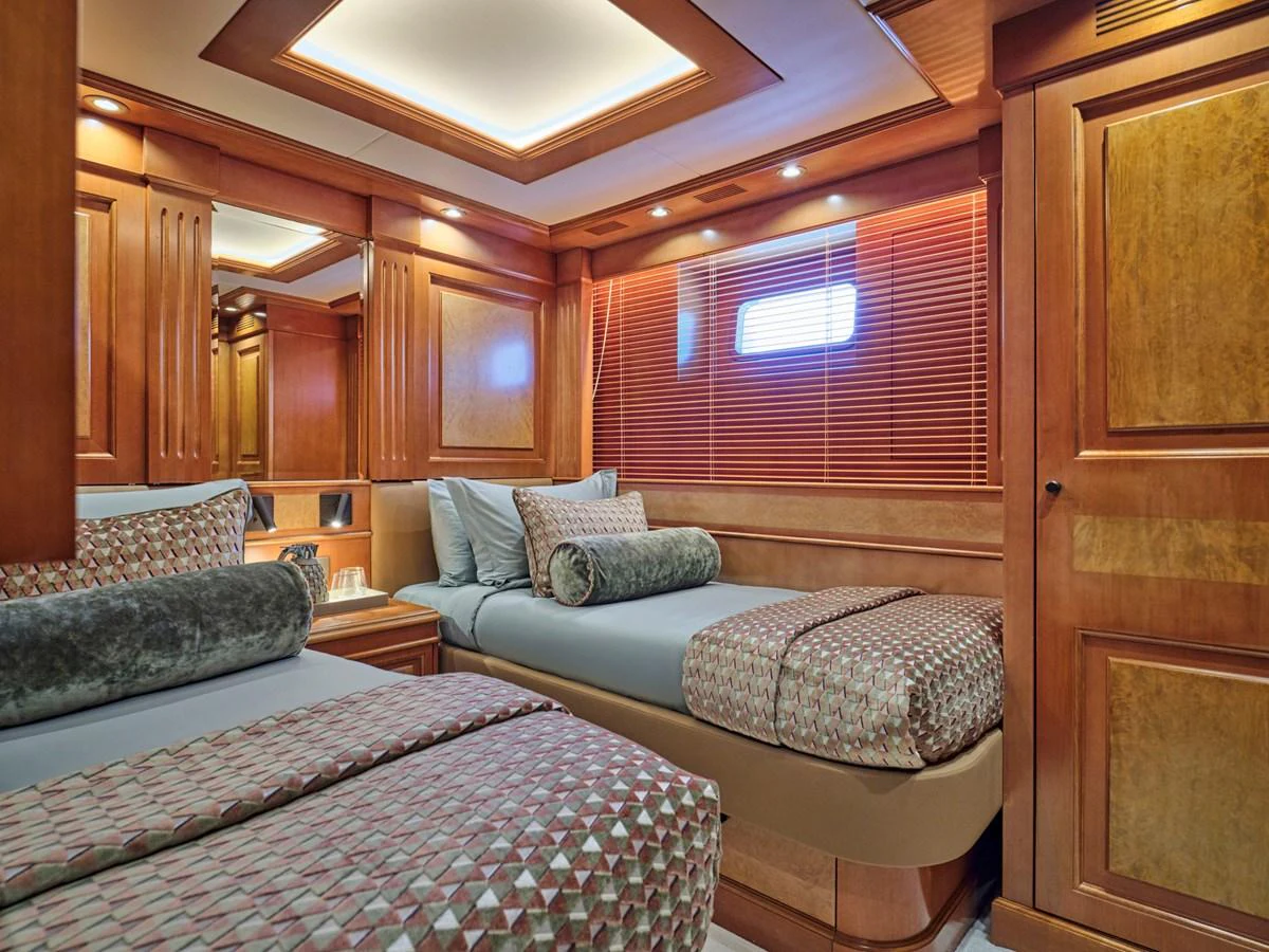 The guest stateroom features twin beds and elegant wood paneling. aboard ULYSSES Yacht for Sale