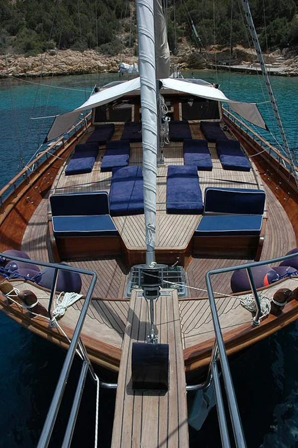 The foredeck features ample sunbathing space with plush blue cushions, perfect for relaxation. aboard TRIPPIN Yacht for Sale
