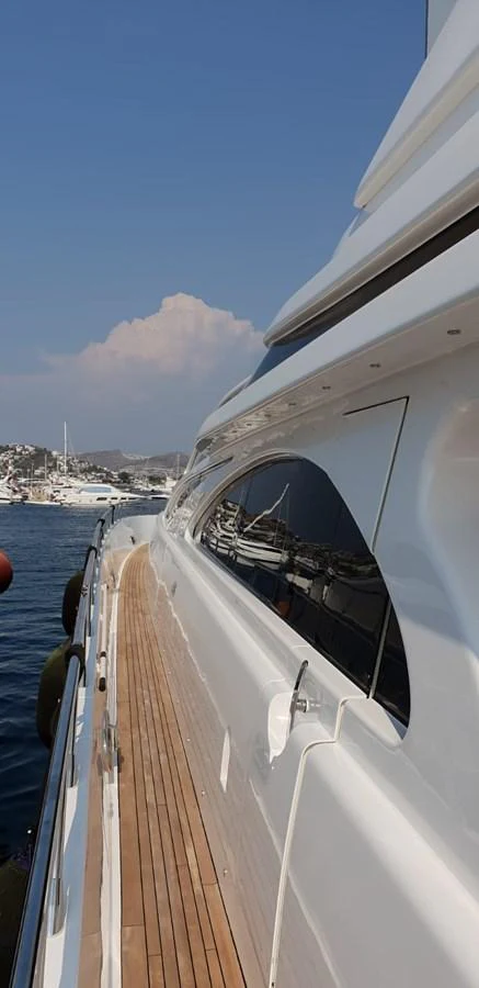 A sleek yacht docked at a marina with a clear view of the surrounding landscape. aboard LEOPARD 105 FT Yacht for Sale