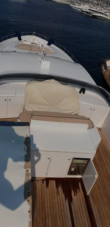 The flybridge offers a spacious area for relaxation and navigation with a view of the marina. aboard LEOPARD 105 FT Yacht for Sale