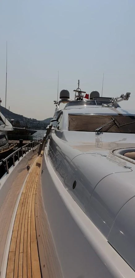 A sleek yacht docked at a marina under clear skies. aboard LEOPARD 105 FT Yacht for Sale