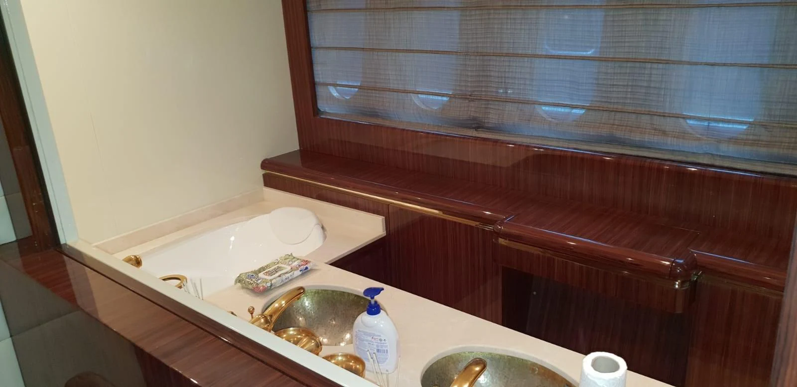 The yacht's bathroom features elegant wooden finishes and gold fixtures, creating a luxurious atmosphere. aboard LEOPARD 105 FT Yacht for Sale