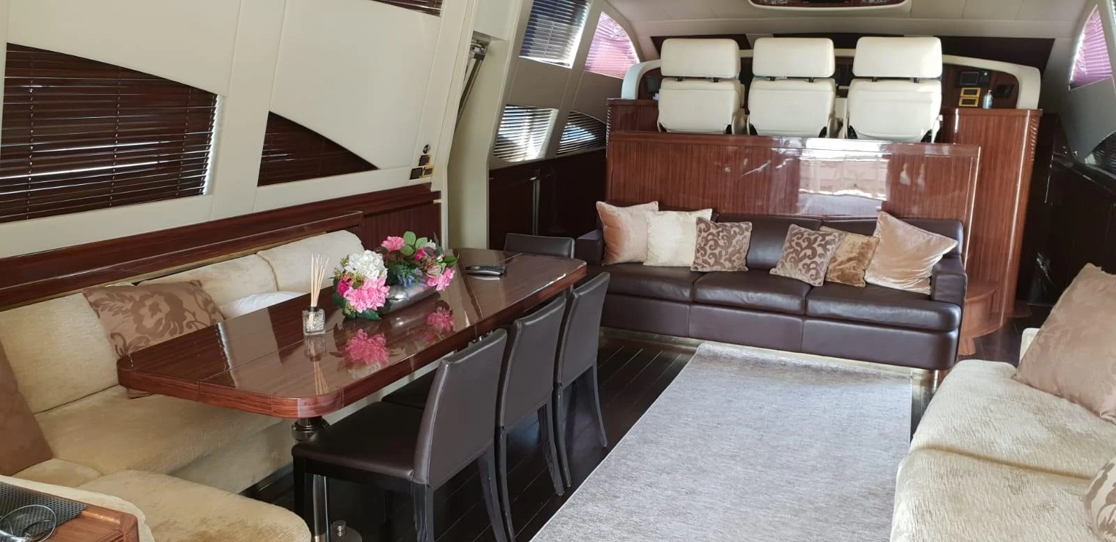 The yacht's salon features a comfortable seating area with a dining table and plush sofas, creating an inviting space for relaxation and socializing. aboard LEOPARD 105 FT Yacht for Sale