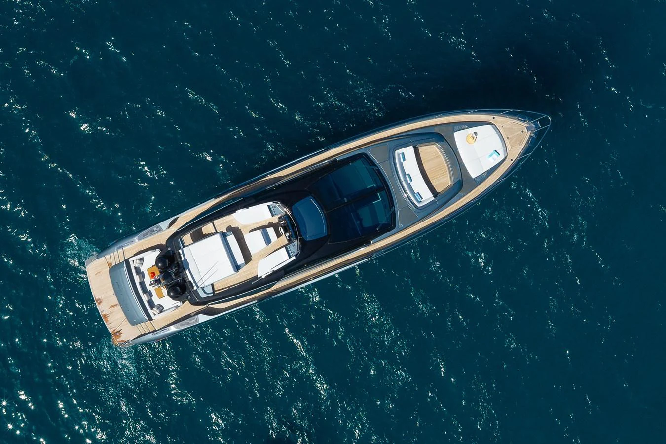 A sleek and modern yacht glides gracefully on the deep blue sea, showcasing its elegant design from an aerial perspective. aboard ACQUA Yacht for Sale
