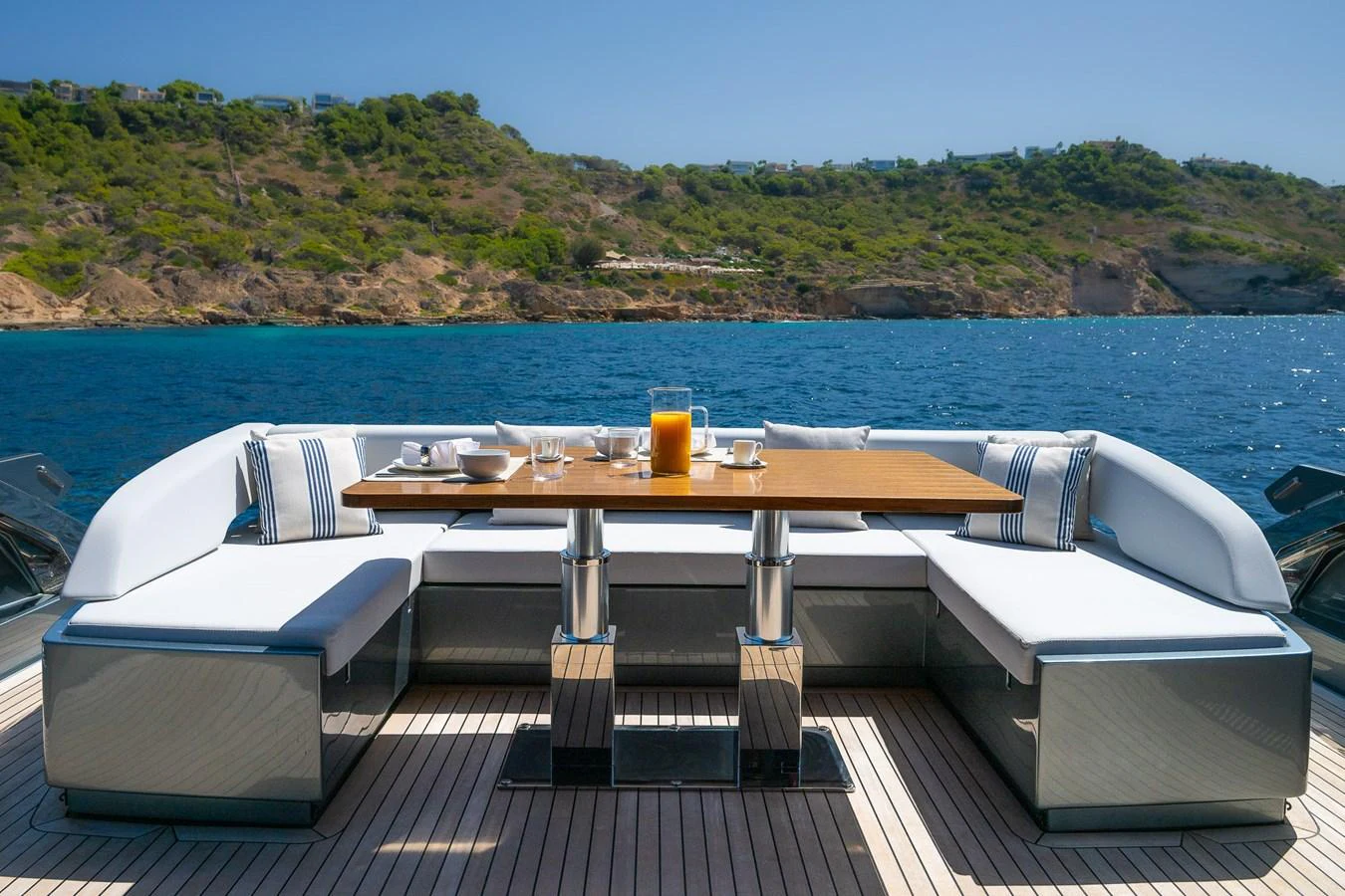 The aft deck features a stylish dining area with a scenic ocean view. aboard ACQUA Yacht for Sale