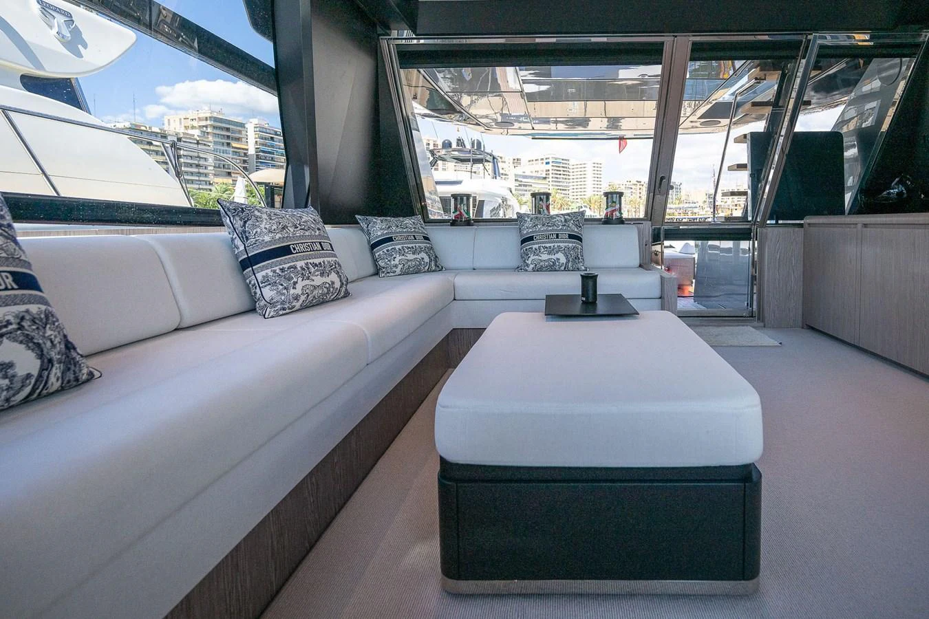The salon features a spacious and comfortable seating area with large windows offering a view of the marina. aboard ACQUA Yacht for Sale