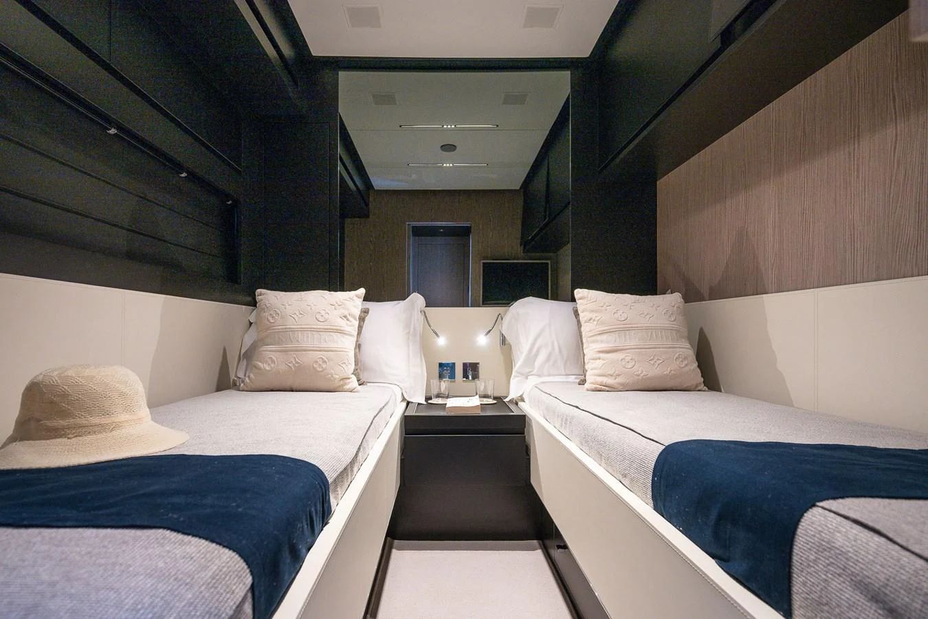A cozy twin stateroom featuring two single beds with plush pillows and a central nightstand. aboard ACQUA Yacht for Sale