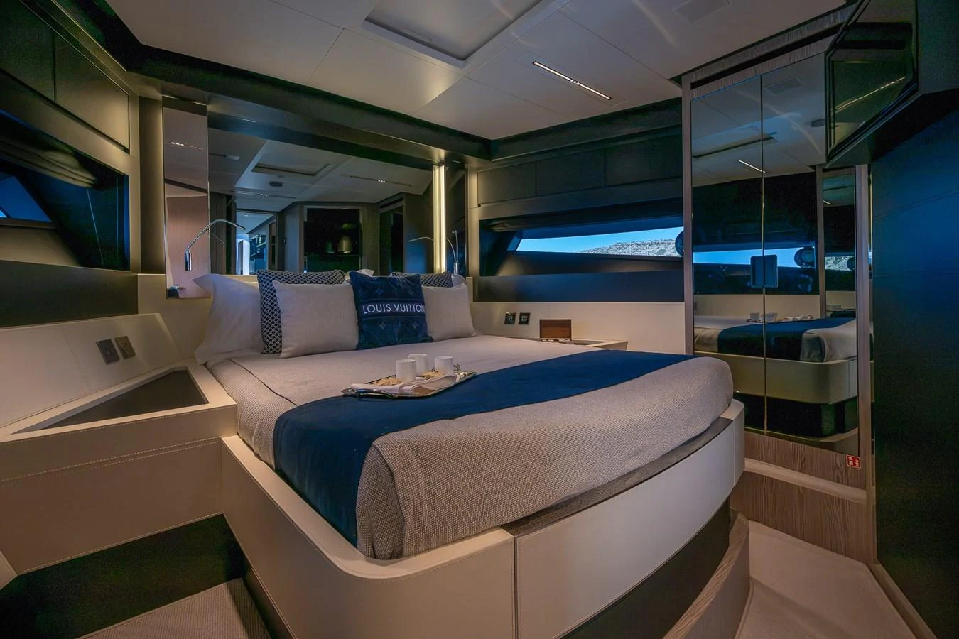 The stateroom features a luxurious bed with elegant bedding and modern design elements. aboard ACQUA Yacht for Sale