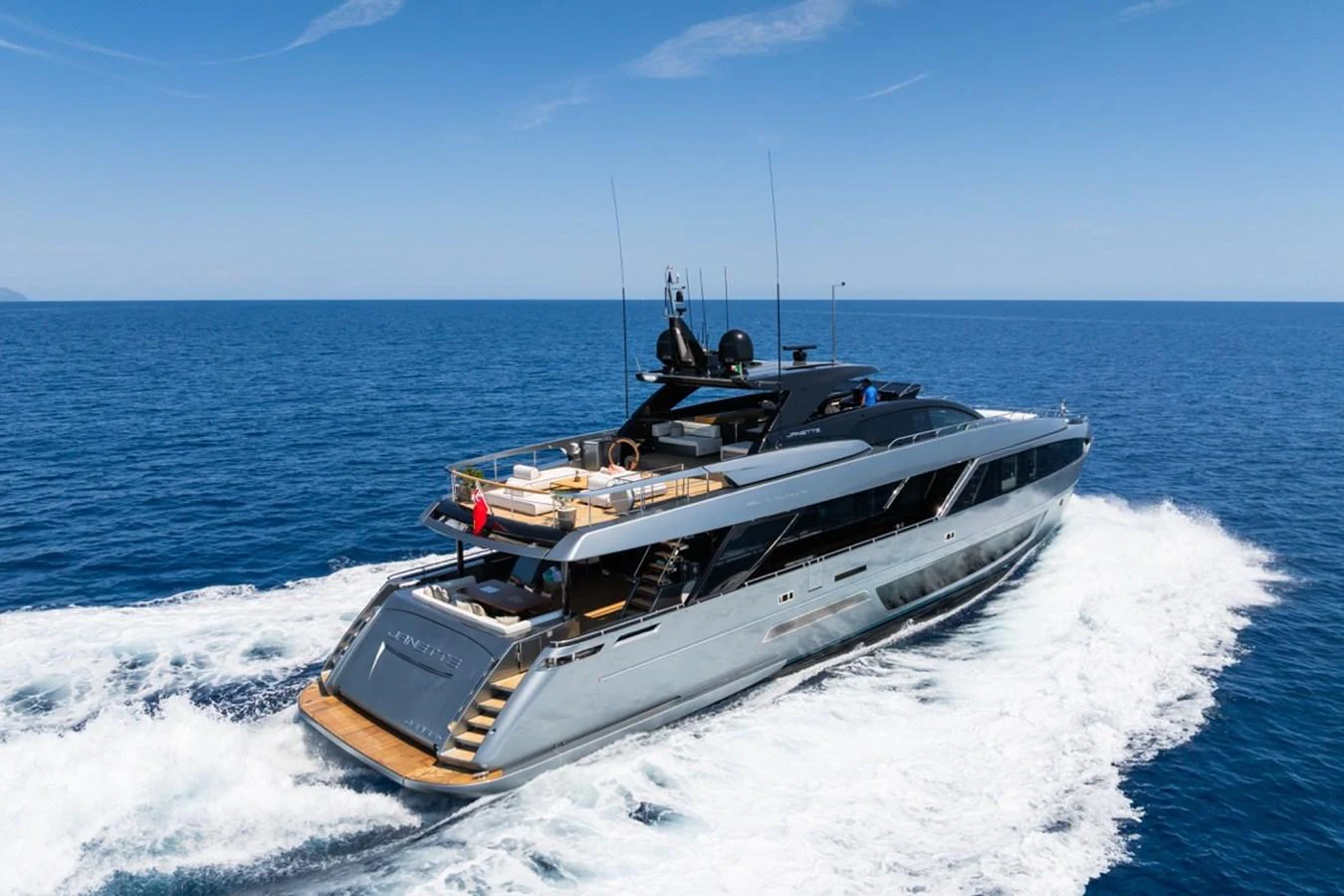 A sleek and modern yacht cruises through the open sea, showcasing its luxurious design and spacious deck. aboard JANETTE Yacht for Sale