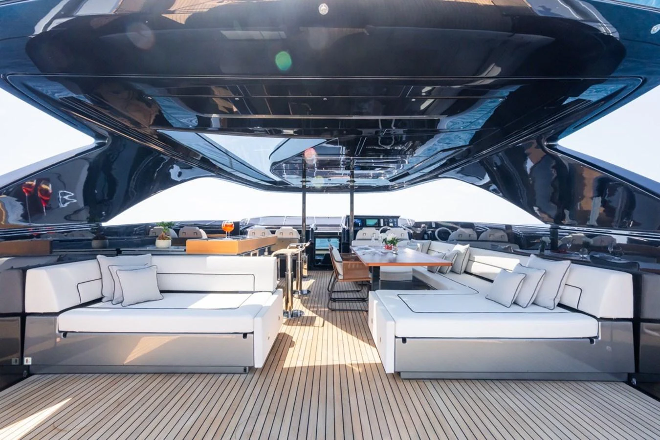 The aft deck features luxurious seating and a dining area under a sleek, modern canopy. aboard JANETTE Yacht for Sale
