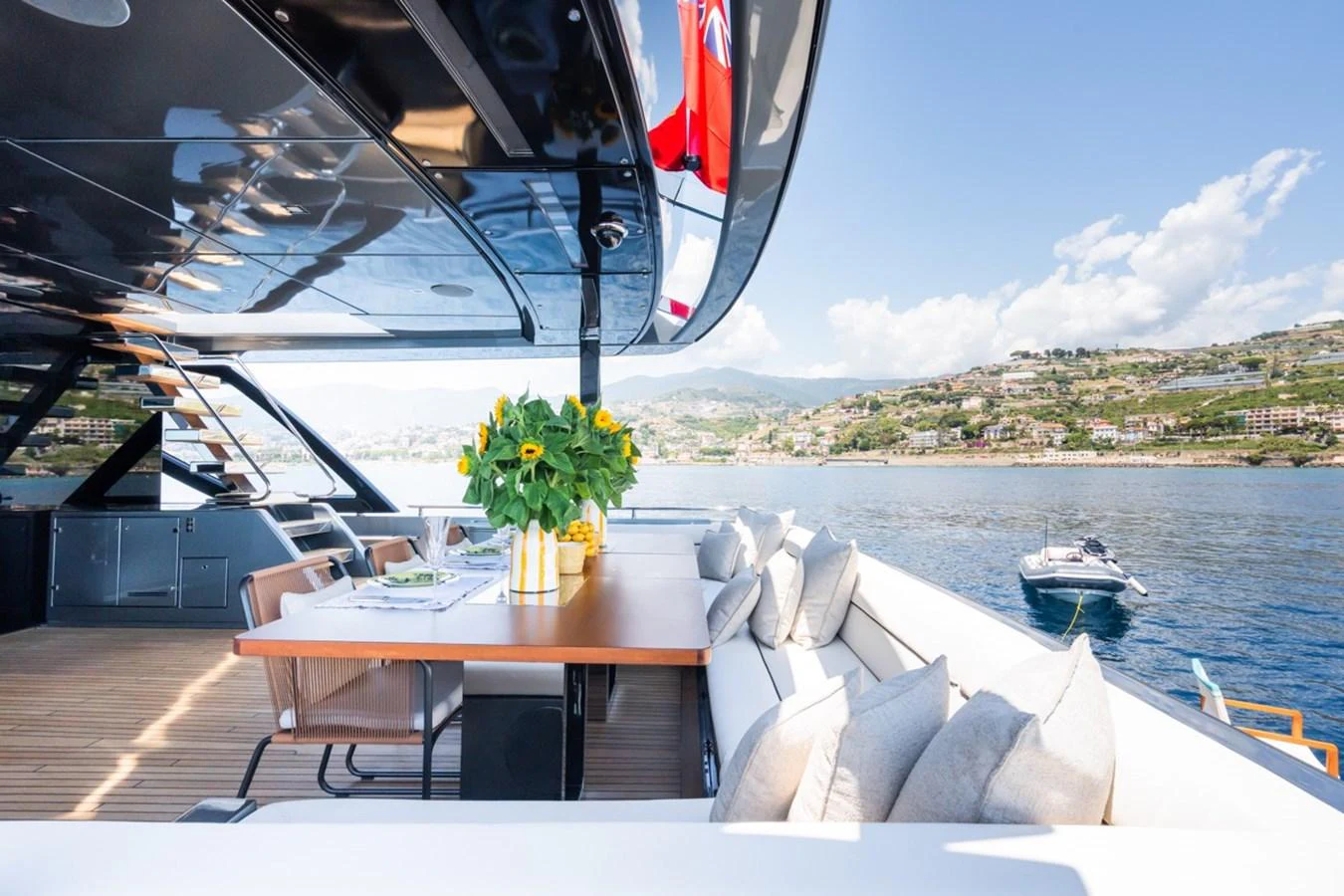The aft deck offers a luxurious outdoor dining area with stunning views of the coastline. aboard JANETTE Yacht for Sale