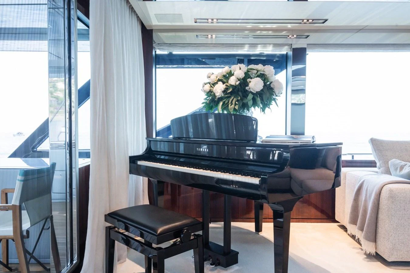 The yacht's salon features a grand piano, plush seating, and elegant decor. aboard JANETTE Yacht for Sale