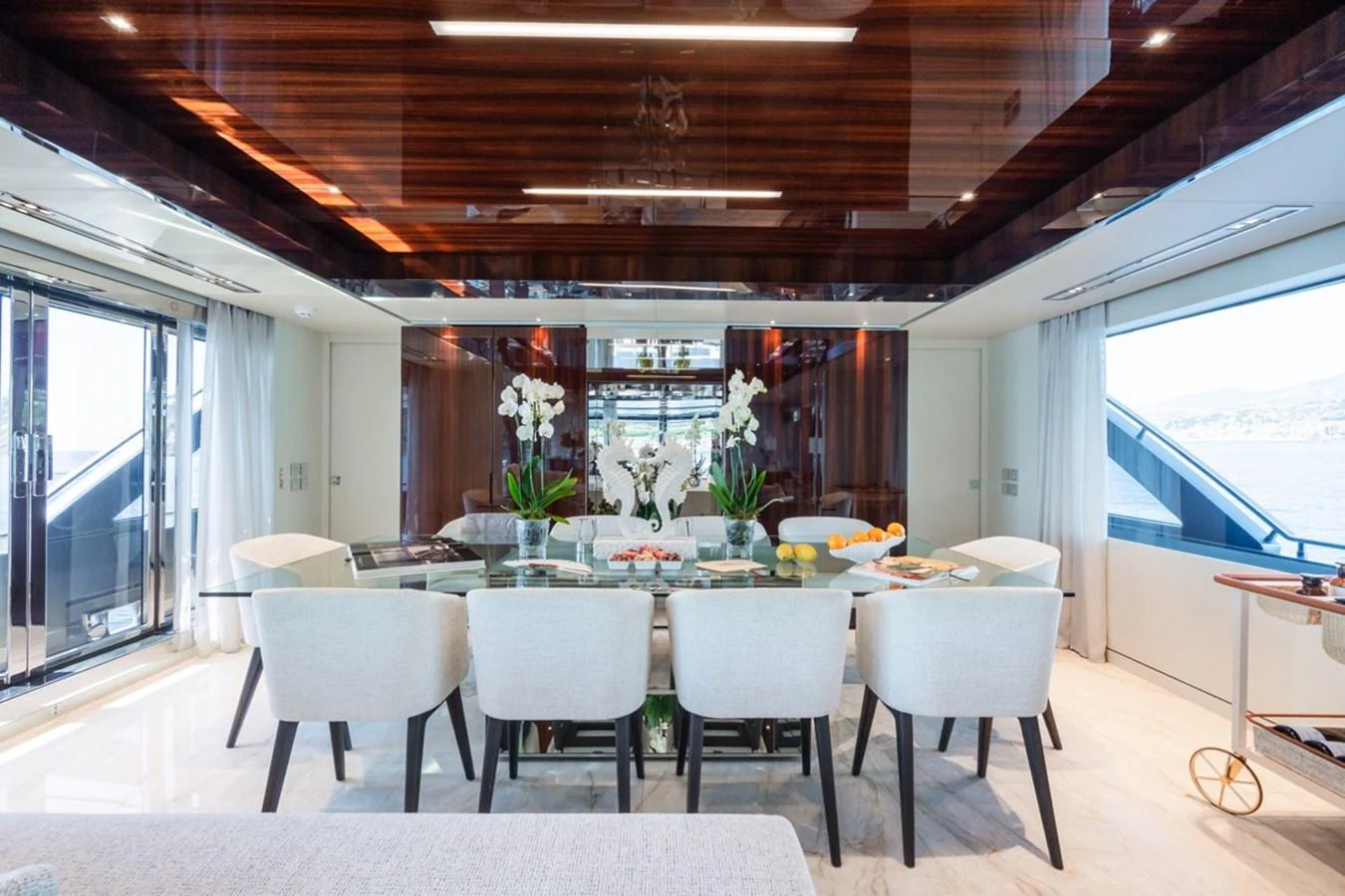 The yacht's dining area features a luxurious table surrounded by elegant seating, with large windows providing ample natural light. aboard JANETTE Yacht for Sale