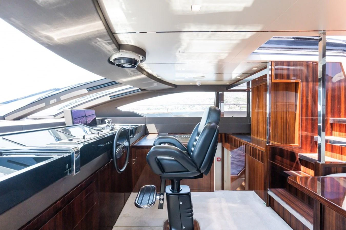 The helm station features a sleek, modern design with luxurious wood finishes and advanced navigation equipment. aboard JANETTE Yacht for Sale