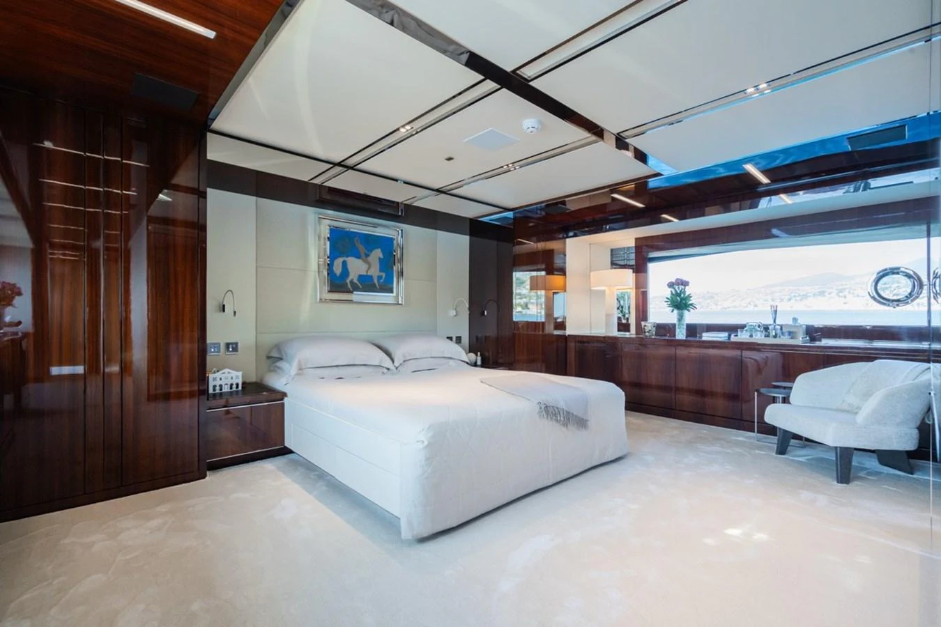 The master stateroom features a luxurious bed with elegant wood paneling and ample natural light. aboard JANETTE Yacht for Sale