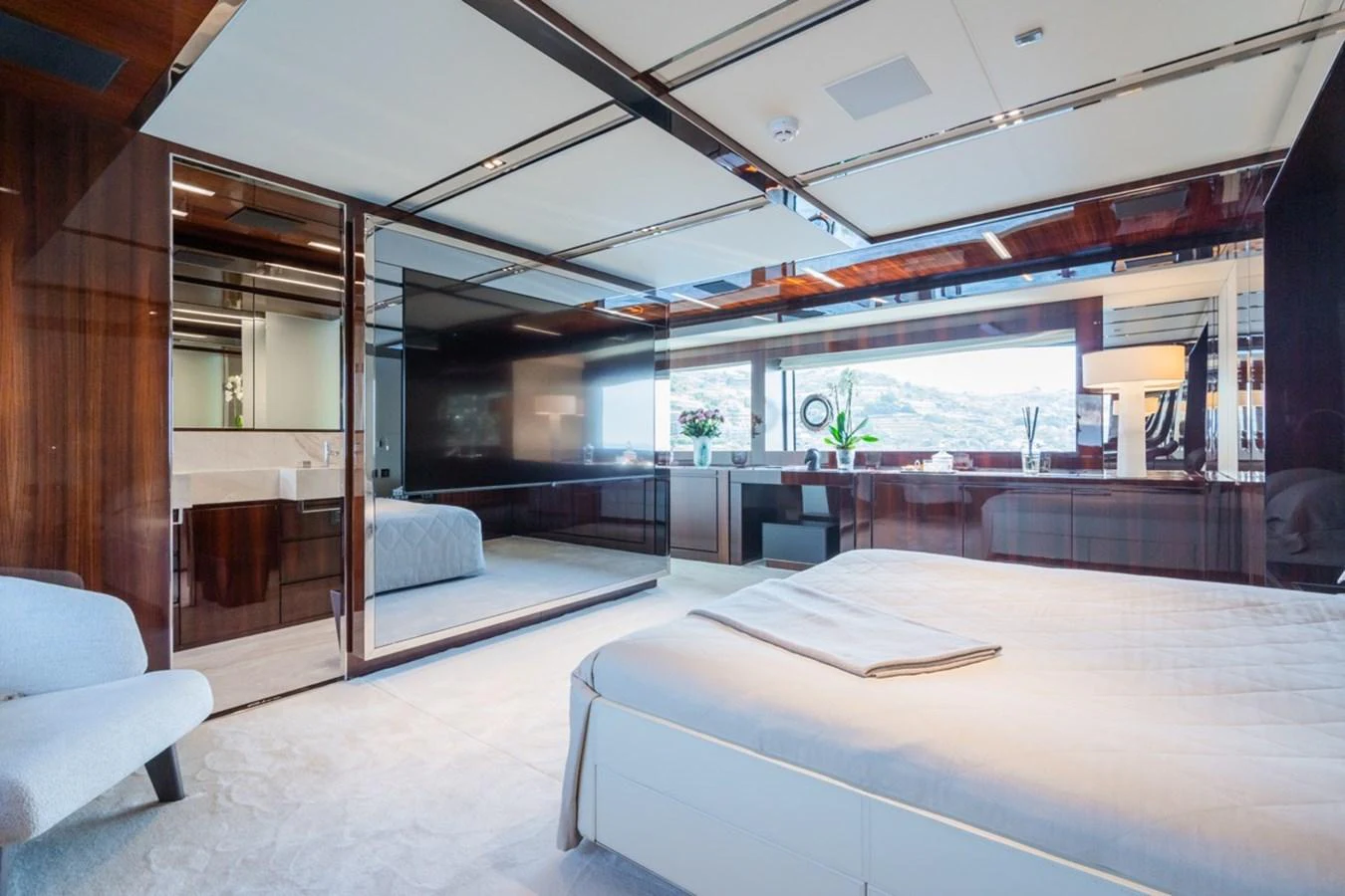 The stateroom features a luxurious bed, modern furnishings, and large windows offering stunning views. aboard JANETTE Yacht for Sale