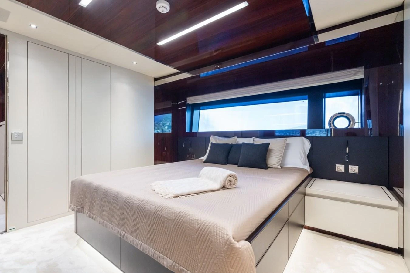 The stateroom features a luxurious bed with elegant bedding and ample natural light from large windows. aboard JANETTE Yacht for Sale