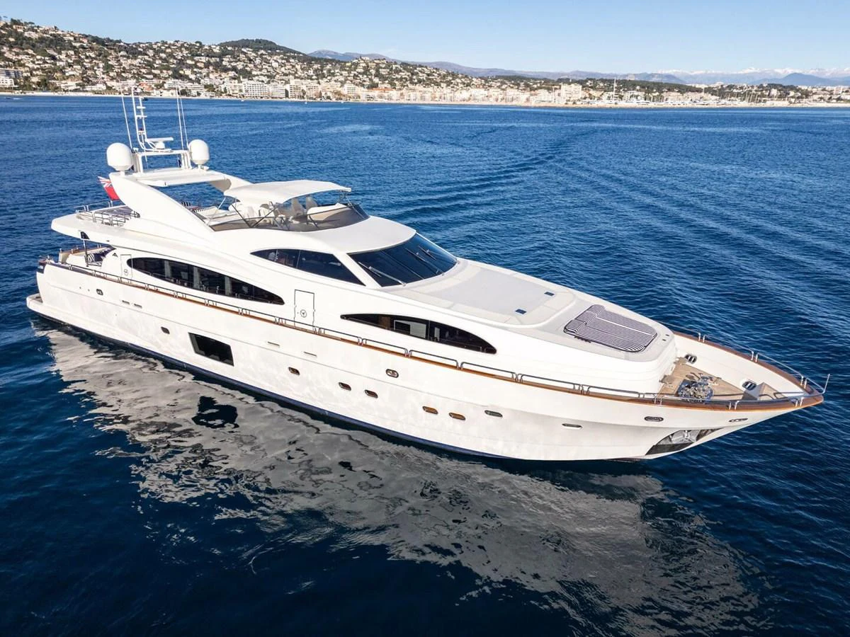 A sleek and modern yacht cruising on calm waters with a scenic coastal backdrop. aboard SPRING TIDE Yacht for Sale