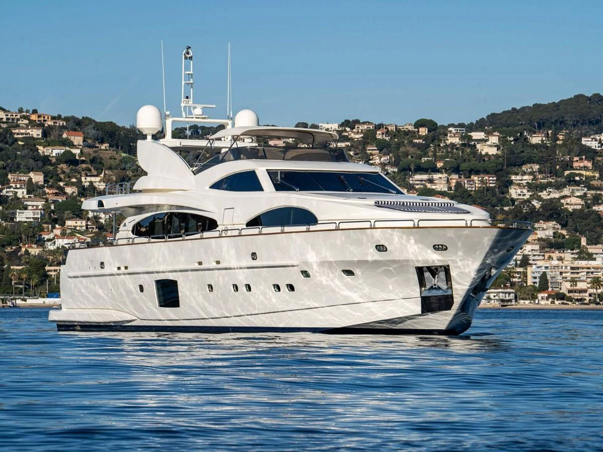 A sleek and modern yacht glides gracefully on calm waters with a scenic coastal backdrop. aboard SPRING TIDE Yacht for Sale