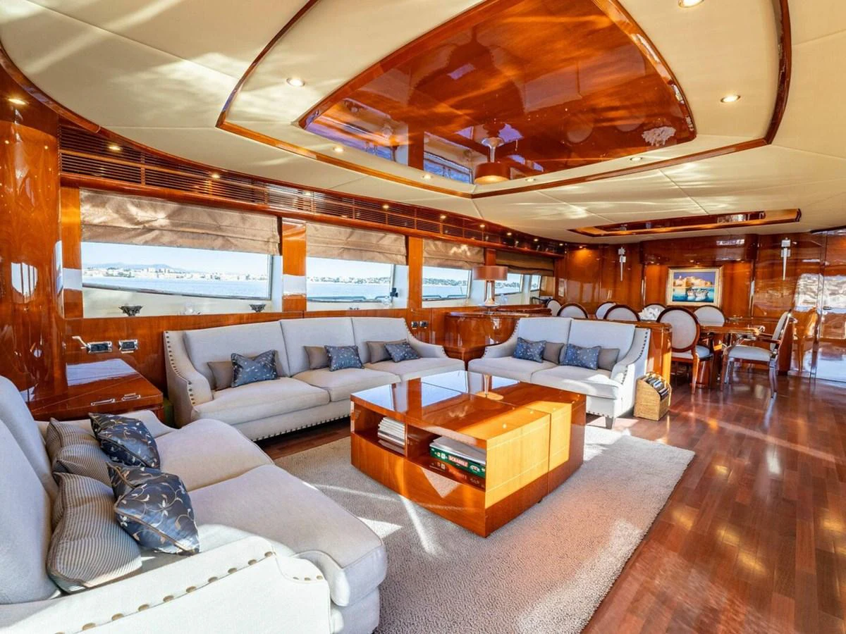 The yacht's salon features luxurious seating and elegant wooden finishes, creating a warm and inviting atmosphere. aboard SPRING TIDE Yacht for Sale