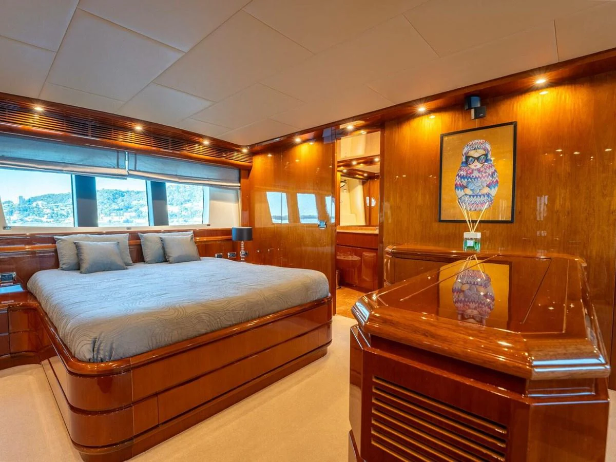 The master stateroom features luxurious wood paneling and a large, comfortable bed with scenic views through the windows. aboard SPRING TIDE Yacht for Sale