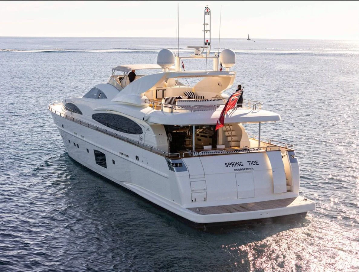 A luxurious yacht glides gracefully on calm waters, showcasing its elegant design and spacious deck areas. aboard SPRING TIDE Yacht for Sale