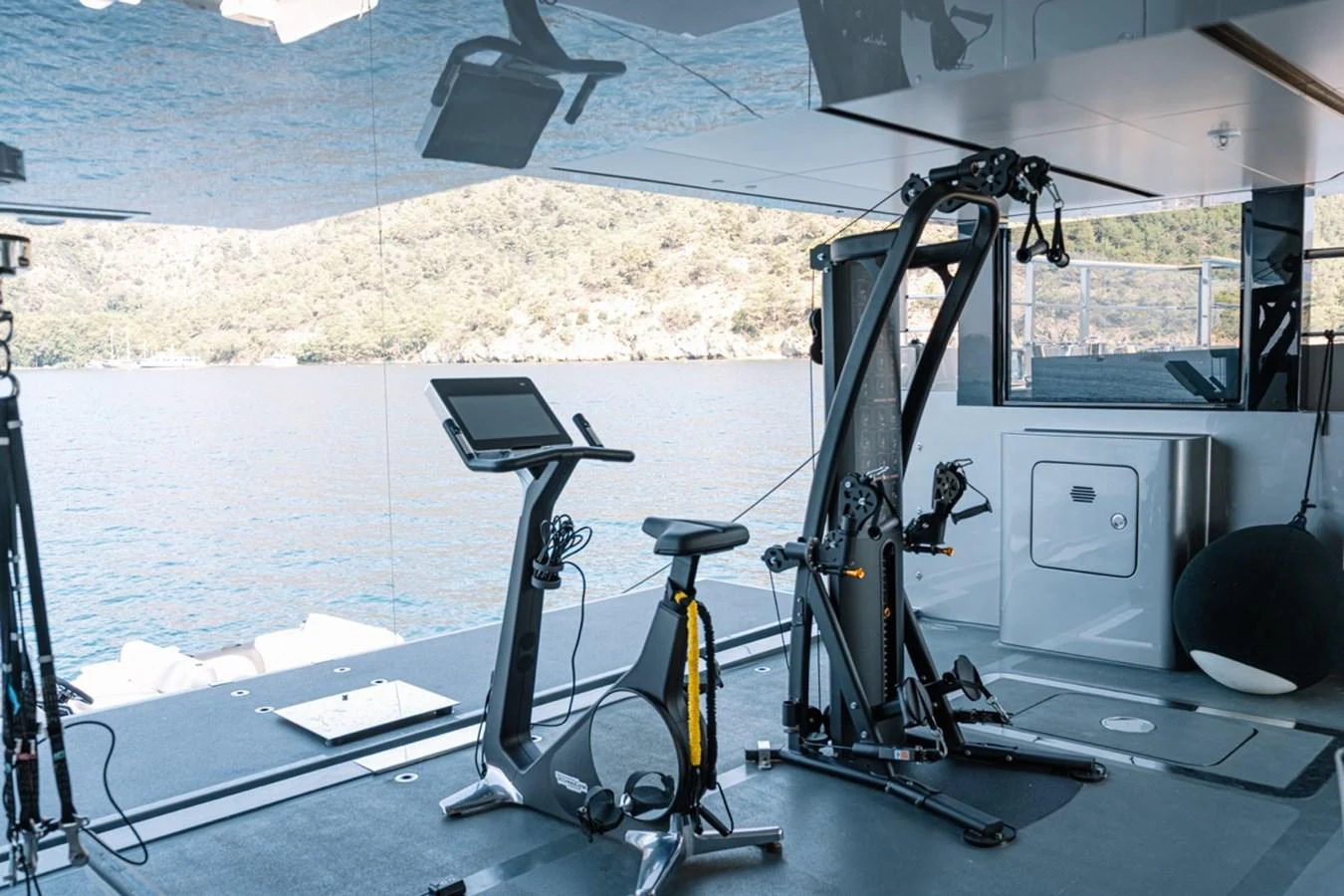 The yacht features a modern gym with state-of-the-art equipment and a scenic view. aboard RAISA Yacht for Sale