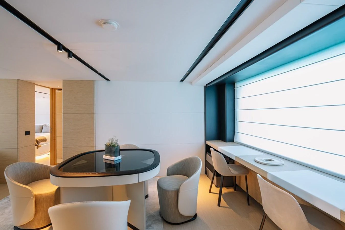 The yacht's interior dining area features a sleek table and comfortable seating with ample natural light. aboard RAISA Yacht for Sale