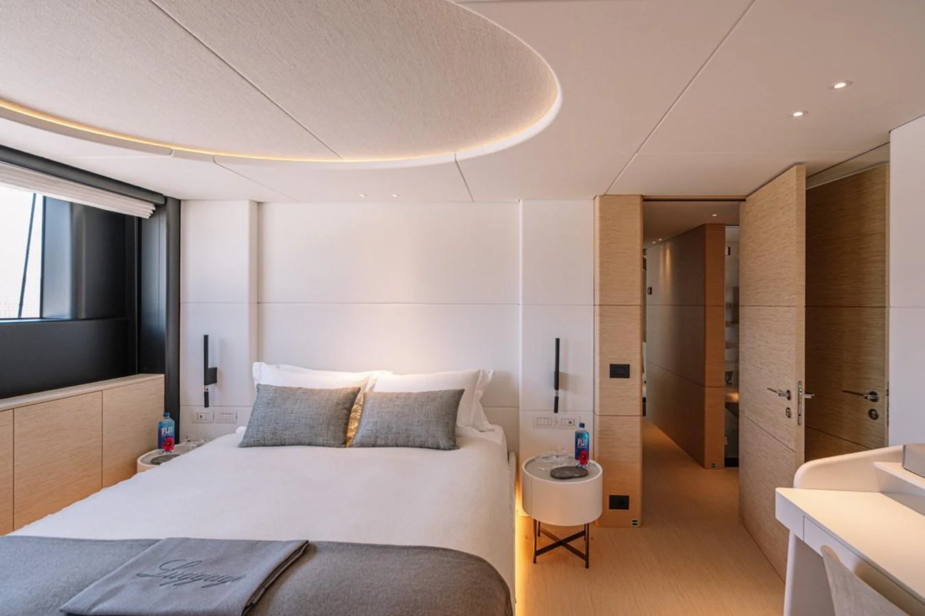 The stateroom features a modern design with a comfortable bed and elegant lighting. aboard RAISA Yacht for Sale