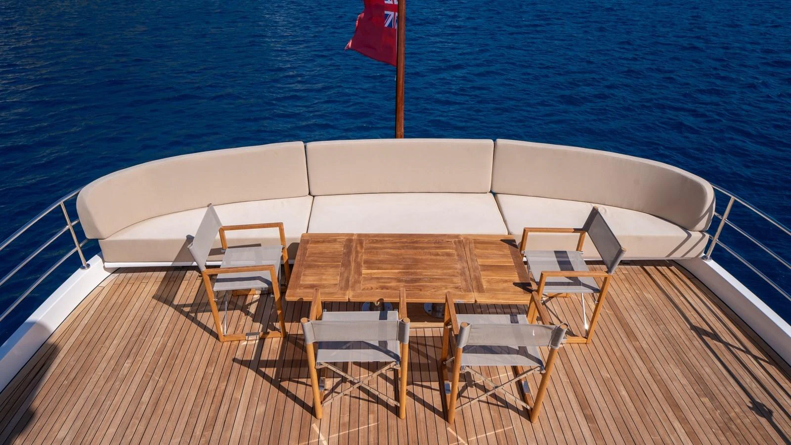 The aft deck features a stylish seating area with a wooden table and chairs, perfect for alfresco dining. aboard TROYWIZARD Yacht for Sale