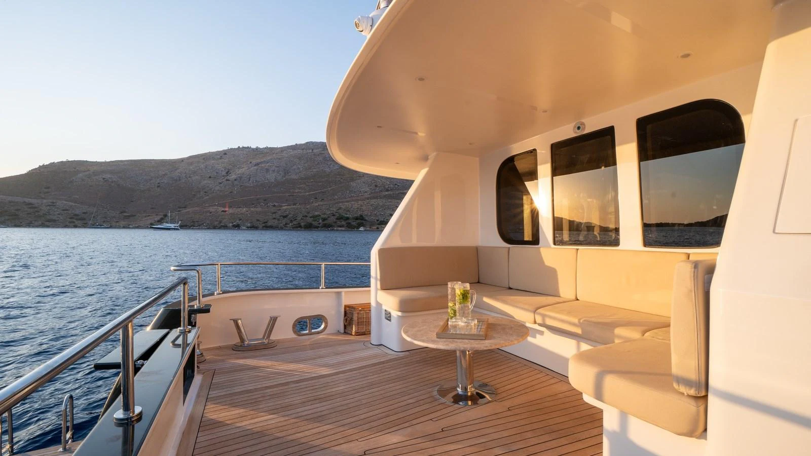 The aft deck offers a serene outdoor seating area with a round table, perfect for enjoying the view. aboard TROYWIZARD Yacht for Sale