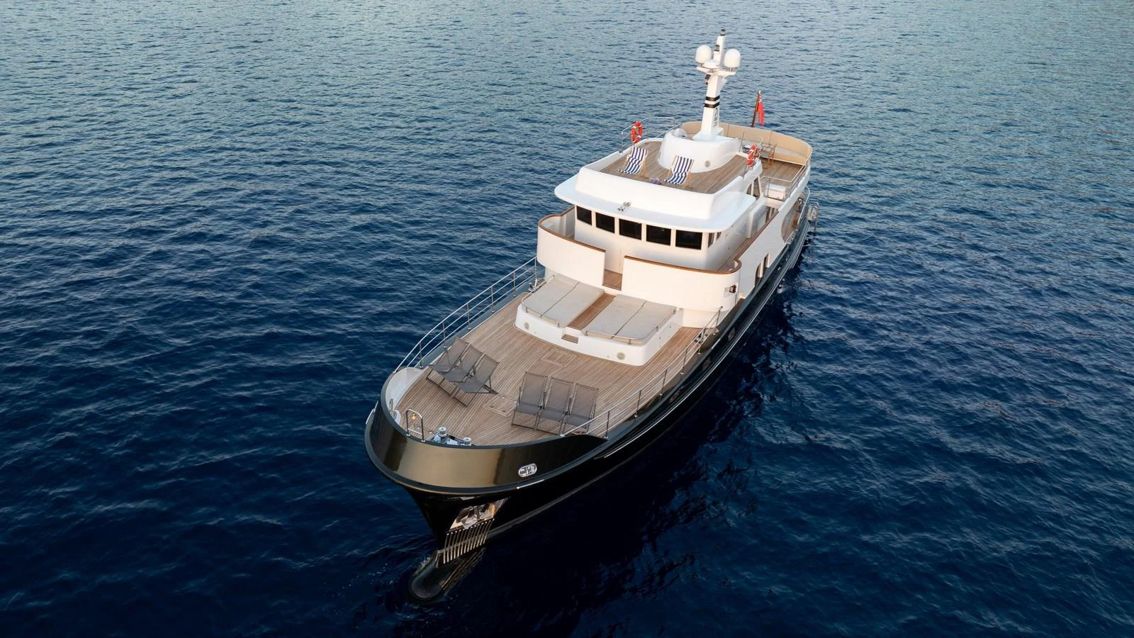 A sleek yacht cruises gracefully on calm blue waters, showcasing its elegant design. aboard TROYWIZARD Yacht for Sale