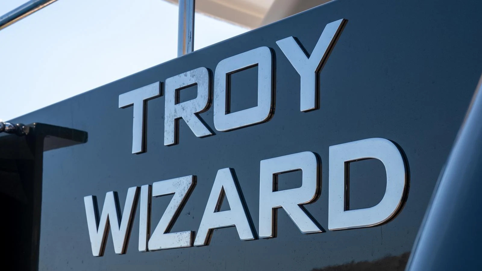 Close-up of the yacht's nameplate with reflective lettering. aboard TROYWIZARD Yacht for Sale