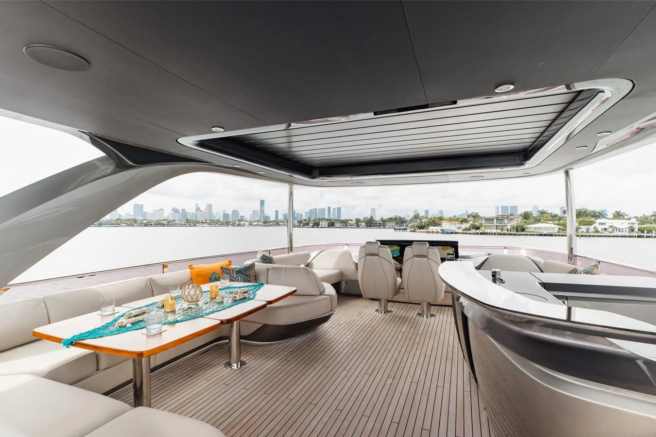 The aft deck features a spacious seating area with a dining table and a bar, offering stunning views of the water. aboard TOMORROW NEVER KNOWS Yacht for Sale
