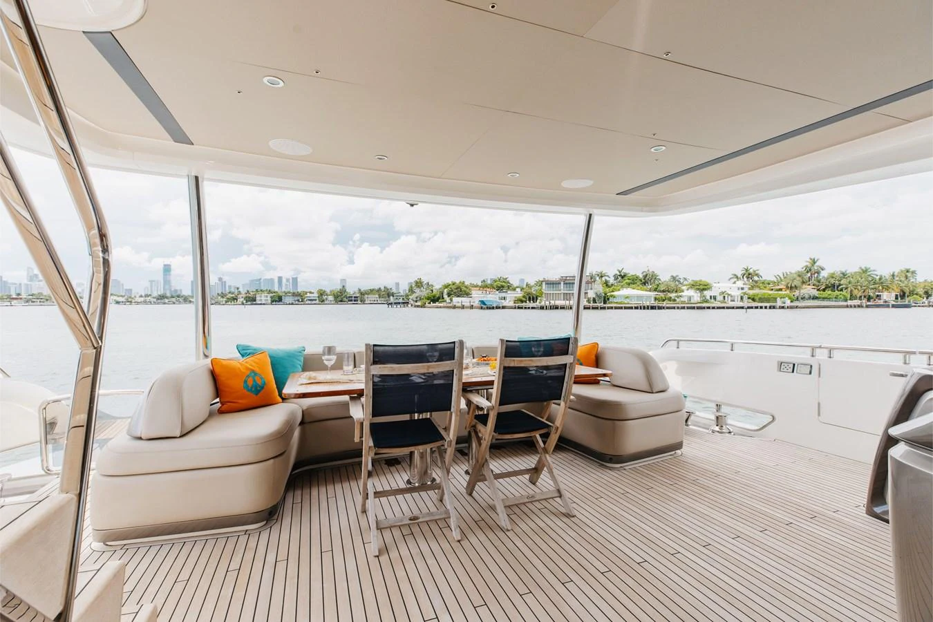The aft deck features a comfortable dining area with a scenic view. aboard TOMORROW NEVER KNOWS Yacht for Sale