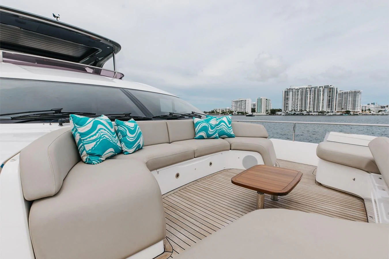 The aft deck features a comfortable seating area with stylish cushions and a wooden table, perfect for relaxing while enjoying the view. aboard TOMORROW NEVER KNOWS Yacht for Sale