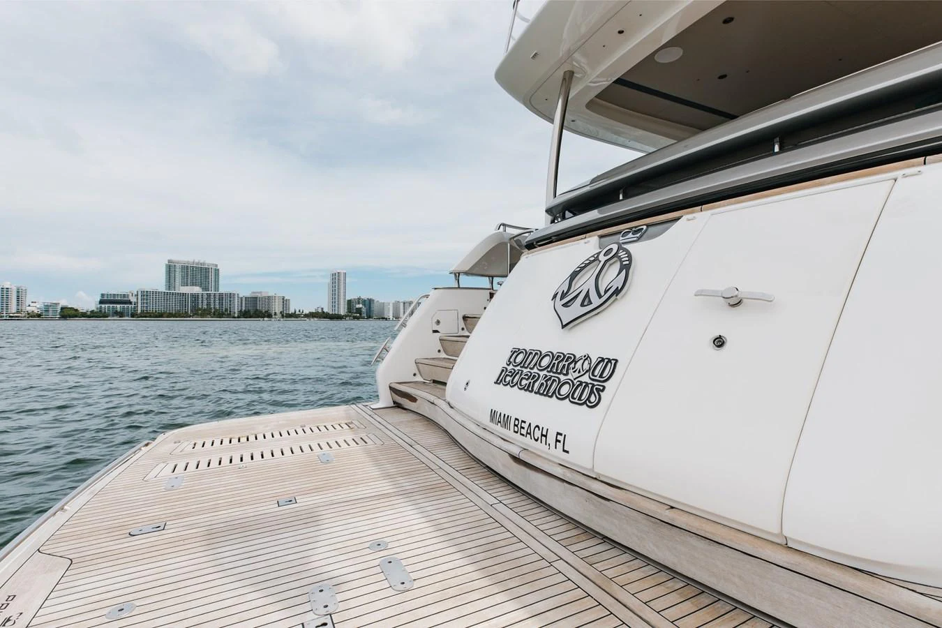 The yacht's aft deck showcases a spacious and inviting area with a view of the water and city skyline. aboard TOMORROW NEVER KNOWS Yacht for Sale