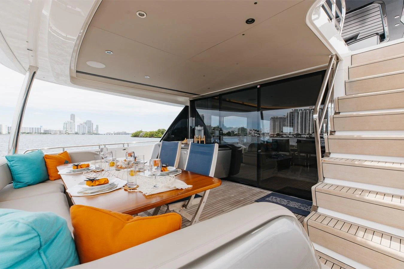 The aft deck offers a luxurious dining area with a view of the city skyline. aboard TOMORROW NEVER KNOWS Yacht for Sale