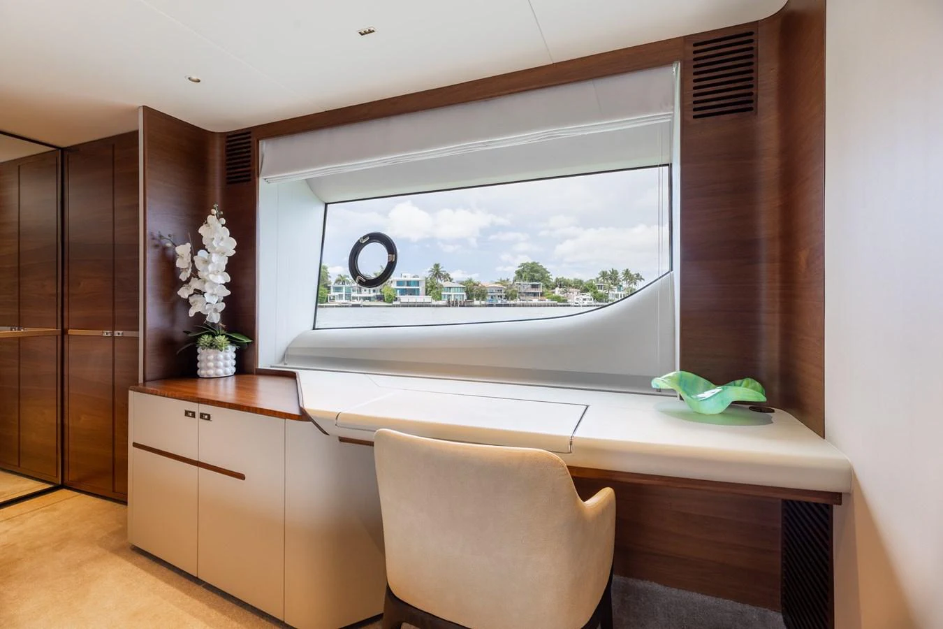 A serene yacht office space with a large window offering a beautiful view of the water. aboard TOMORROW NEVER KNOWS Yacht for Sale