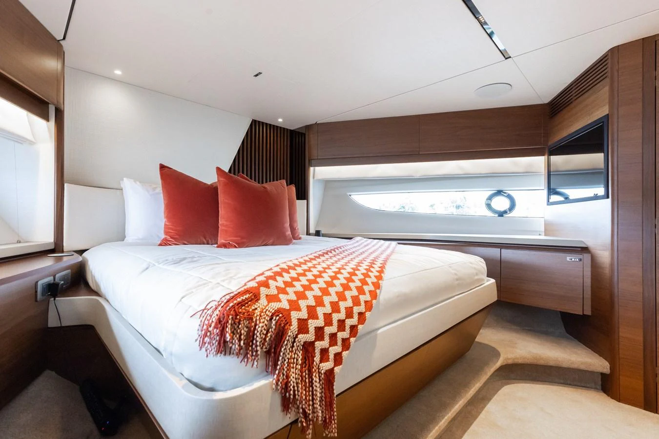 The stateroom features a luxurious bed with plush pillows and a stylish throw blanket, creating a cozy and inviting atmosphere. aboard TOMORROW NEVER KNOWS Yacht for Sale