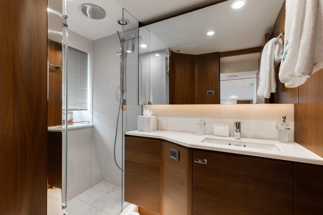 The yacht's bathroom features sleek wood cabinetry and modern fixtures. aboard TOMORROW NEVER KNOWS Yacht for Sale